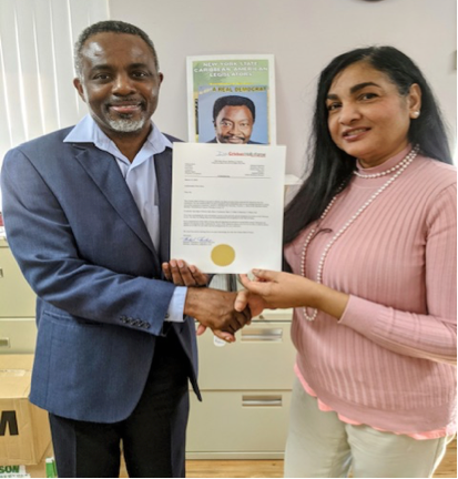 Ruby Harrisingh (right) delivers the good news to Dolton Robinson (Chief of Staff) for Ambassador Nick Perry